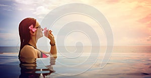 beautiful woman in pool by the sea enjoying a tropical vacation