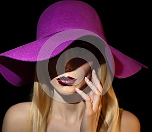 Beautiful woman portrait. Fashion art photo. Beautiful young model with mauve hat on colored background, studio shot