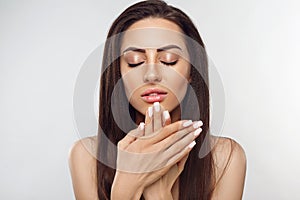 Beautiful woman portrait, skin care concept Portrait of female hands with french manicure nails touching her face