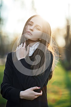 Beautiful woman portrait in sun light on sunset time in city par