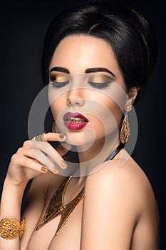 Beautiful woman portrait. Young lady posing with gold jewelry.