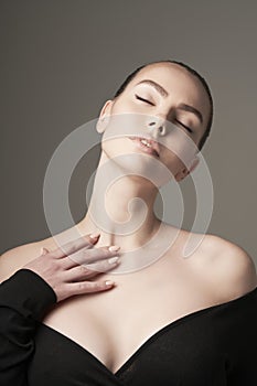 Beautiful woman pose in studio. Art portrait of a model in a black dress