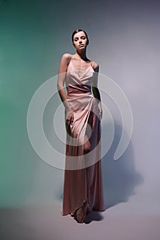 Beautiful woman pose in studio in pink classic dress