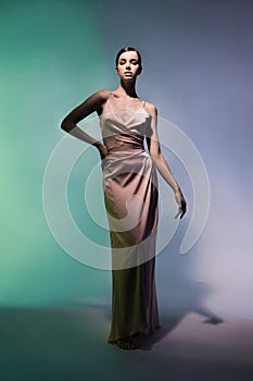 Beautiful woman pose in studio in pink classic dress