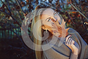 Beautiful woman posing with autumn leaf