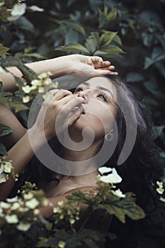 Beautiful woman posing among flowers