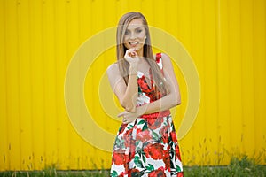 Beautiful woman posing in fron of yellow wall