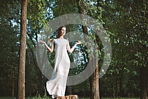 Beautiful Woman Posing like Goddess in White Long Dress at Nature. Boho Style, Soul Calm, Wellness. Freedom and Relaxing