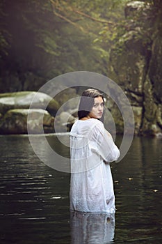 Beautiful woman posing in a mountain stream