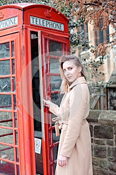 Beautiful woman posing near red telephone box in London