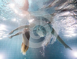 Beautiful woman posing underwater in white dress