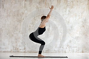 Beautiful woman practicing yoga, Chair exercise, Utkatasana pose photo