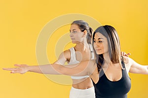 Beautiful woman practicing yoga, conducting a training session with female students, showing the correct execution of