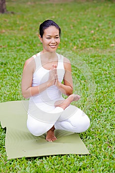 Beautiful woman practicing yoga in the park