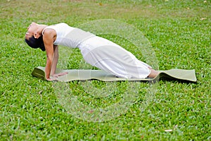 Beautiful woman practicing yoga in the park