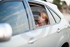 Beautiful woman preens in the car