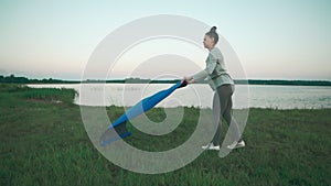 Beautiful woman prepare to do morning yoga practice. Girl holding blue yoga mat