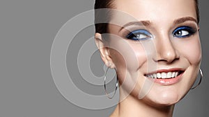 Beautiful Woman with Professional Blue Makeup. Celebrate Style Eye Make-up and Shine Skin. Smiling Fashion Model