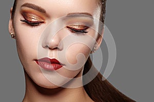 Beautiful Woman with Professional Makeup. Party Gold Eye Make-up, Perfect Eyebrows, Shine Skin. Bright Fashion Look