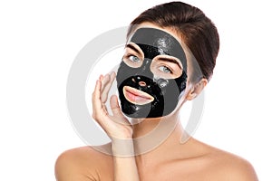 Beautiful woman with a purifying black mask on her face