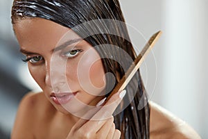 Beautiful Woman Putting Mask On Long Wet Hair. Hairbrushing