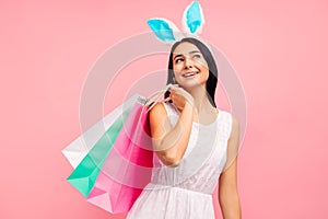 Beautiful woman in rabbit ears with shopping bags in her hands, spring shopping, a traditional holiday