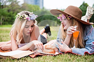 Beautiful woman read text book and lay on mat and grass field with friend