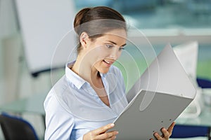 beautiful woman reading from ring binder folder photo