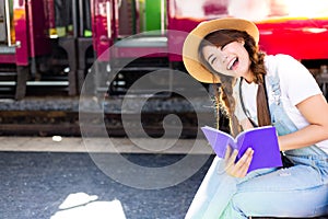 Beautiful woman is reading travel guide book for looking tourist