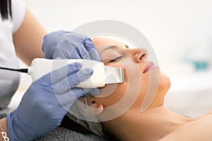 Beautiful woman receiving skin cleansing procedure in cosmetologically clinic