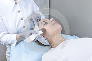 Beautiful woman receiving ultrasound cavitation facial peeling