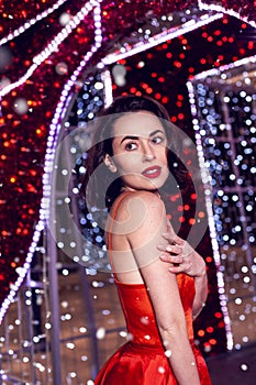 Beautiful woman in red dress in christmas decor background beauty portrait photoshoot