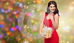 Beautiful woman in red dress with gift box
