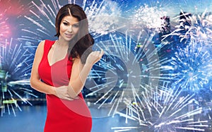 Beautiful woman in red dress over firework