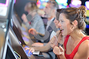 Beautiful woman in red dress playing slot machine