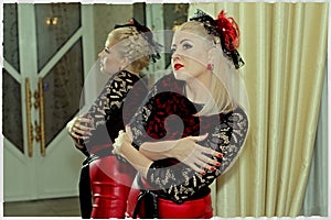 The beautiful woman in a red dress and a red hat at a mirror