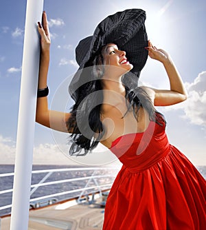 Beautiful woman in red dress on the yacht