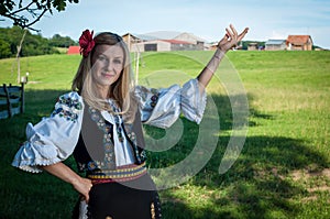 Beautiful woman with red flower in her hair posing in Romanian t