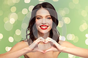 Beautiful woman with red lipstick and hand heart