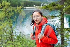 Beautiful woman in red raincoat hiking. Earazing bad energy with outdoor activity