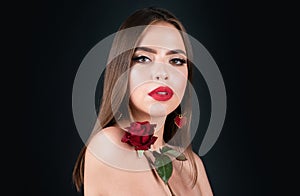 Beautiful woman with red rose flower isolated on black background. Pink lips and rose. Beauty girl. Sensual sexy mouth
