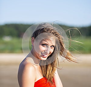 Beautiful woman in red shawl posing on sea beach