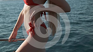 Beautiful woman in red swimming suit posing and fixing hair