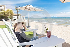 Beautiful woman is relaxing on the beach , under umbrella