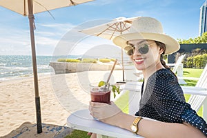 Beautiful woman is relaxing on the beach , under umbrella