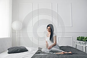 Beautiful woman relaxing on the bed and using her tablet