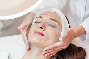 Beautiful woman relaxing during facial massage for rejuvenation