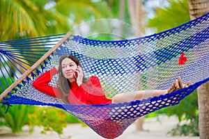 Beautiful woman relaxing at hammock on tropical beach