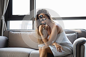 Beautiful woman is relaxing at home with black peel-off mask on her face