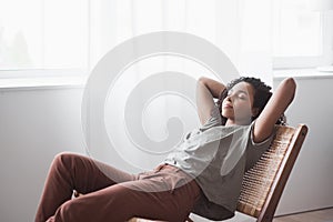 Beautiful woman relaxing at home. Cute african american girl resting in her room.